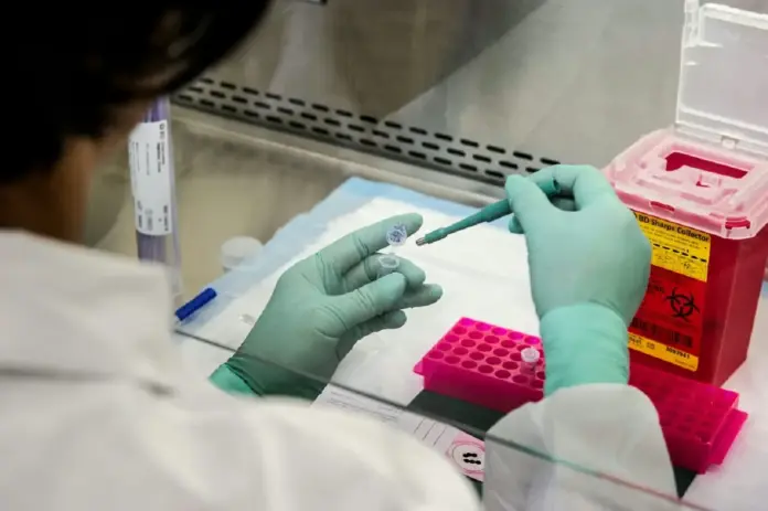 Persona trabajando en un laboratorio. Foto de CDC en Unsplash